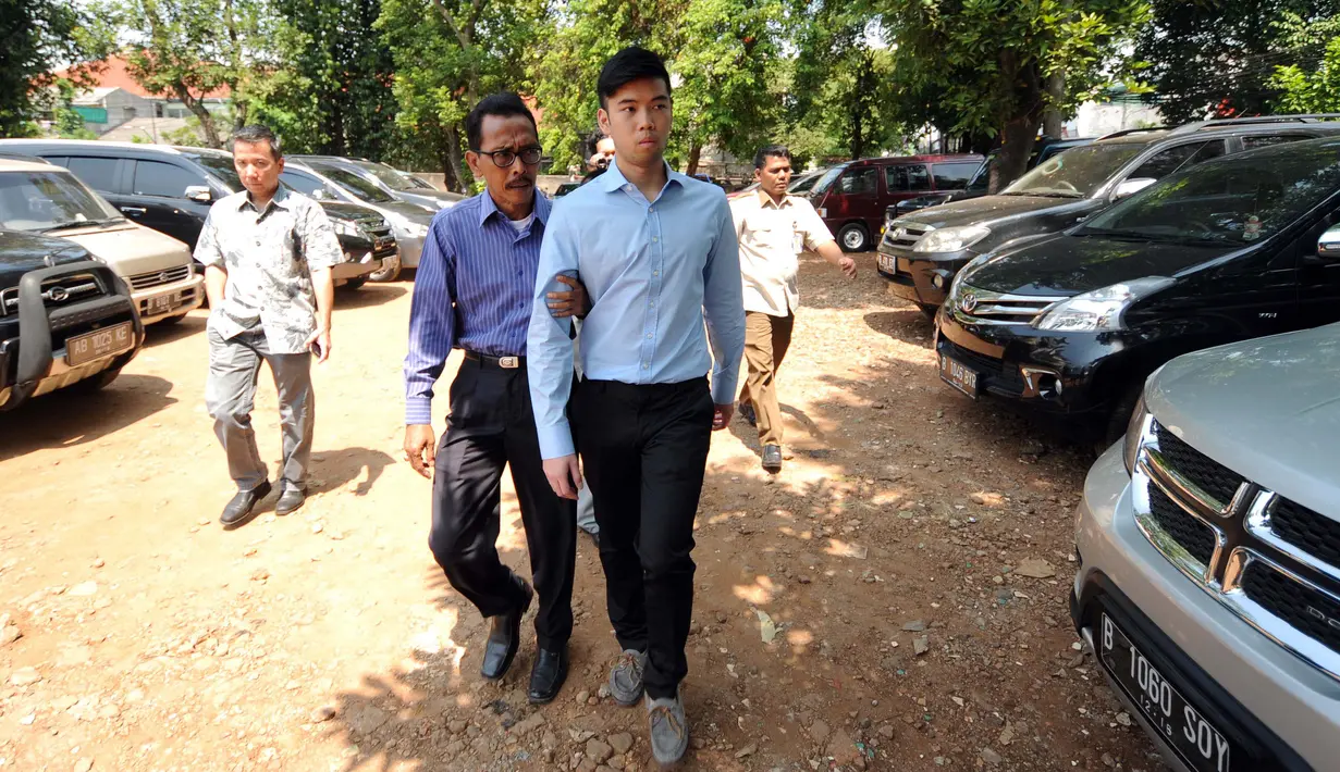 Petugas mengawal terdakwa kasus kecelakaan maut Pondok Indah, Christopher Daniel Syarief (tengah) meninggalkan Pengadilan Negeri Jakarta Selatan, Rabu (5/8/2015). Christopher dituntut 2 tahun 6 bulan. (Liputan6.com/HelmiFithriansyah)