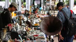Penggemar barang antik menyaksikan pagelaran 'Jakarta Vintage Weekend Market', di Tugu Proklamasi, Jakarta, Minggu (20/12/2015). Kegiatan ini dalam rangka mengumpulkan sumbangan untuk para veteran yang hidup miskin. (Liputan6.com/Faizal Fanani)