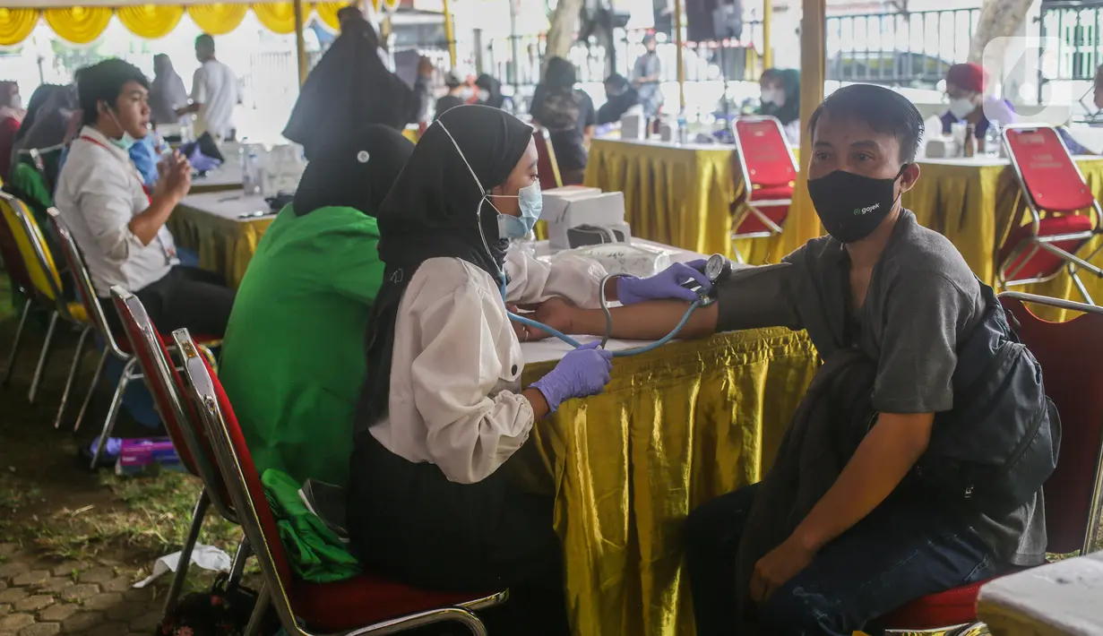 Petugas medis mengecek kesehatan warga sebelum mengikuti program vaksinasi massal Covid-19 di PMI Kota Bekasi, Jawa Barat, Sabtu (21/08/2021). PMI Kota Bekasi bekerjasama dengan Puskesmas Marga Jaya melaksanakan vaksinasi Covid-19 secara massal untuk 2000 peserta. (Liputan6.com/Herman Zakharia)