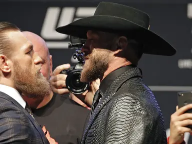 Conor McGregor (kiri) bertatap muka dengan Donald "Cowboy" Cerrone saat konferensi pers untuk pertarungan seni bela diri campuran UFC 246 di Las Vegas (15/1/2020). Keduanya dijadwalkan bertarung dalam pertarungan kelas welter pada Minggu (19/1) siang WIB. (AP Photo/John Locher)