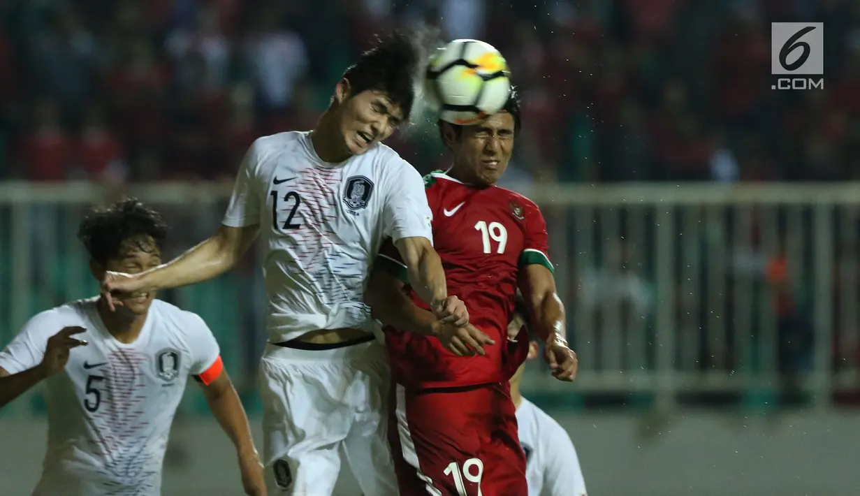 Gelandang Indonesia U-23, Hanif Abdurrauf Sjahbandi (kanan) berebut bola atas dengan pemain Korea Selatan U-23, Lee Sangmin pada laga persahabatan di Stadion Pakansari, Kab Bogor, Sabtu (23/6). Indonesia U-23 kalah 1-2. (Liputan6.com/Helmi Fithriansyah)