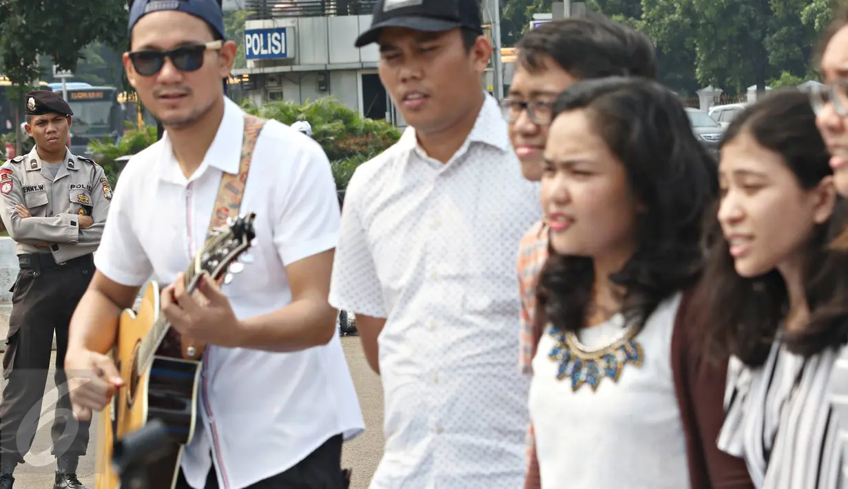 Seorang polisi menyimak kegiatan yang dilakukan jemaat GKI Yasmin & HKBP Filadelfia di depan Istana Negara, Jakarta, Minggu (17/1/2016). Mereka berharap pemerintah memberikan solusi bagi permasalahan tempat ibadah mereka. (Liputan6.com/Immanuel Antonius)