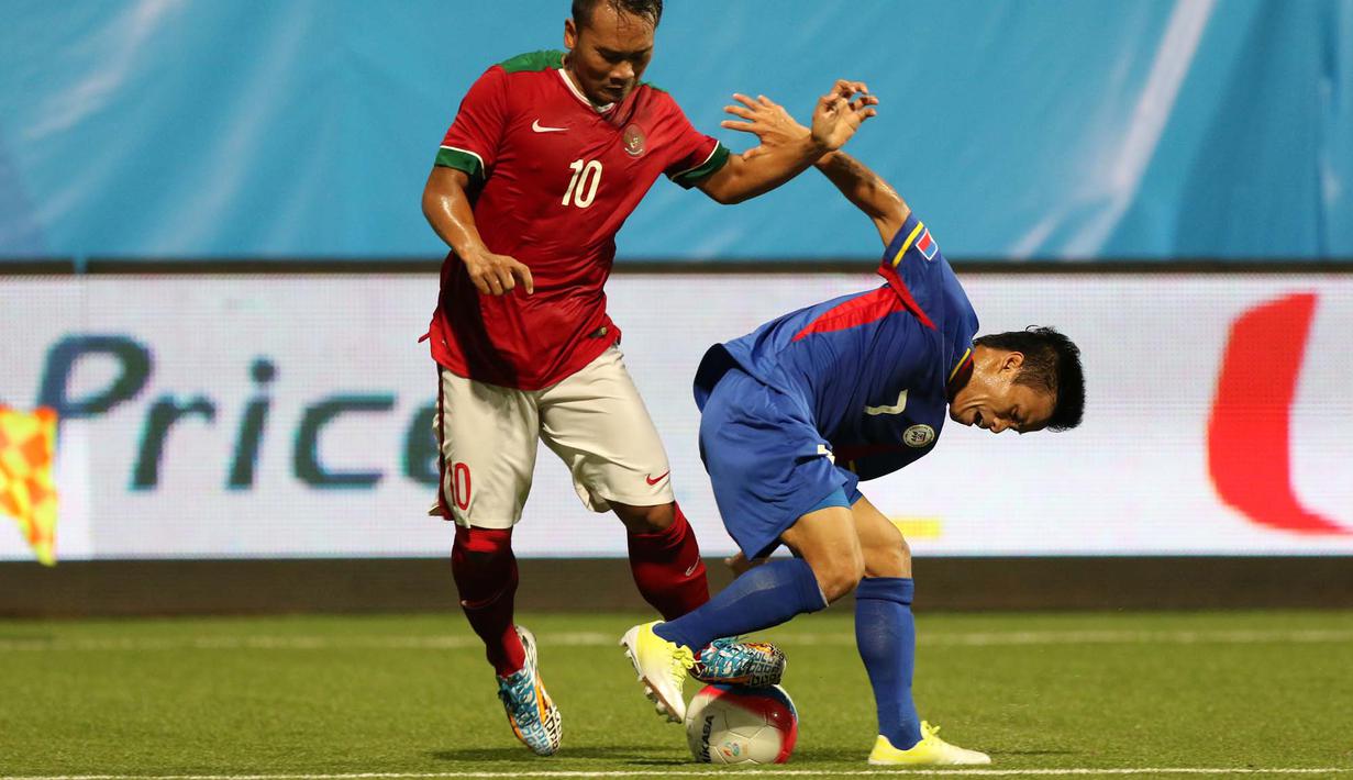 Pemain Indonesia U-23, Wawan Pebriyanto (kiri), berebut bola dengan pemain Filipina U-23, Arnel Amita, dalam penyisihan Grup A Sepakbola SEA Games 2015 di Stadion Jalan Besar, Singapura. Selasa (9/6). (Bola.com/Arief Bagus)