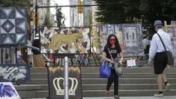Seorang wanita mengamati karya seni yang dipajang di area terbuka dalam pameran Art Downtown, Vancouver, British Columbia, Kanada, 4 September 2020. Art Downtown merupakan proyek yang memungkinkan seniman dan publik saling terhubung dan menginspirasi serta berbagi kreativitas. (Xinhua/Liang Sen)