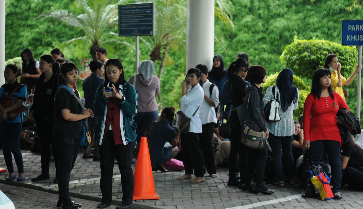 Sejumlah karyawan pertokoan Pondok Indah Mall 1 Jakarta berkumpul di depan pintu 2 Pondok Indah Mall 1 Jakarta. Sebuah ruangan di lantai 2 pusat perbelanjaan Pondok Indah Mall (PIM) I, Jakarta terbakar, Senin (20/4/2015). (Liputan6.com/Helmi Fithriansyah)