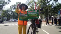 Sariban terus mengingatkan warga Bandung untuk tidak membuang sampah sembarangan pada pawai Obor Asian Games di Kota Bandung. (Liputan6.com/Cakrayuri Nuralam)