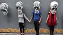 Sejumlah orang berfoto dengan replika tengkorak saat pameran dan kontes di perayaan Hari Kematian di Mexico City (1/11). Di Meksiko ada Festival El Dia de Los Muertos atau hari orang mati yang digelar setiap tahunnya. (AFP Photo/Yuri Cortez)