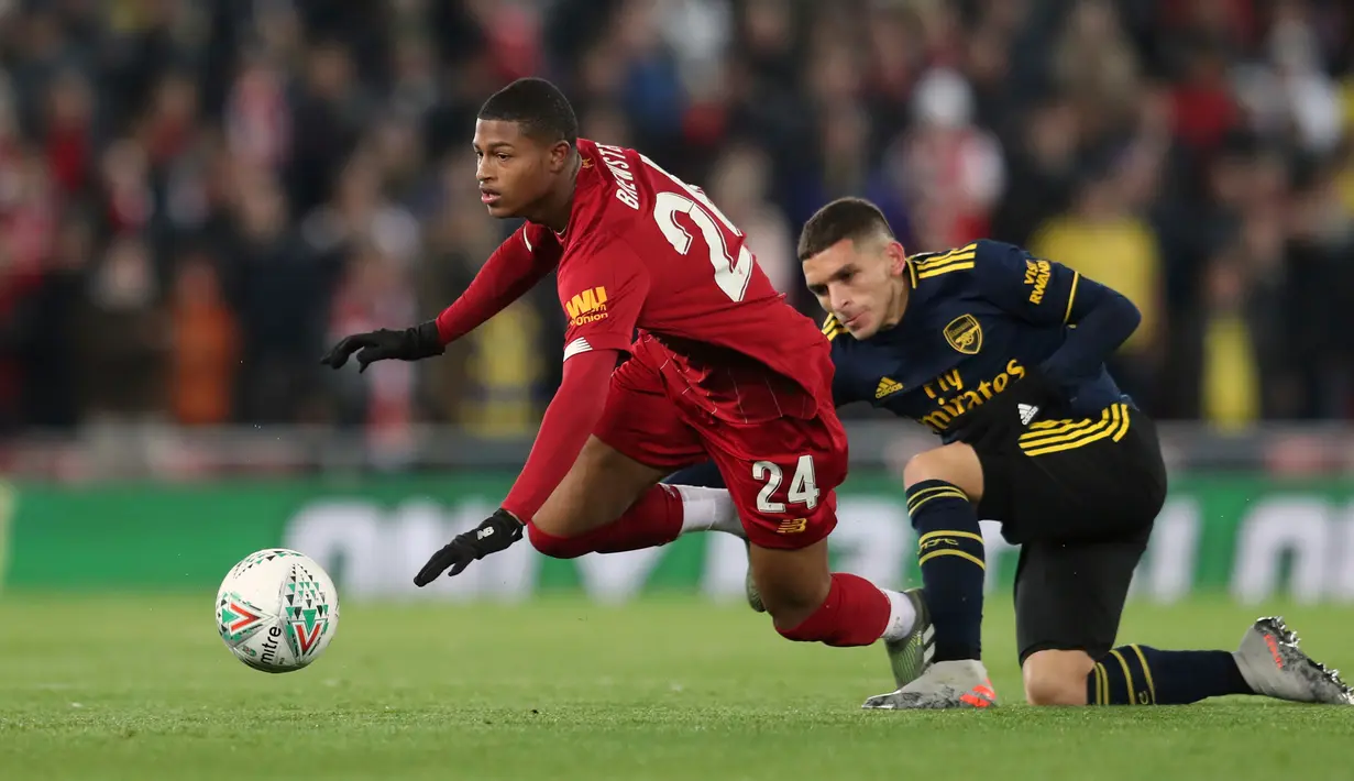 Bintang muda Liverpool, Rhian Brewster berebut bola dengan pemain Arsenal Lucas Torreira pada laga babak 16 Besar Carabao Cup di Anfield Stadium, Rabu (30/10/2019). Berimbang 5-5 di waktu normal, Liverpool menang 5-4 dalam adu penalti dan maju ke perempatfinal . (AP/Jon Super)