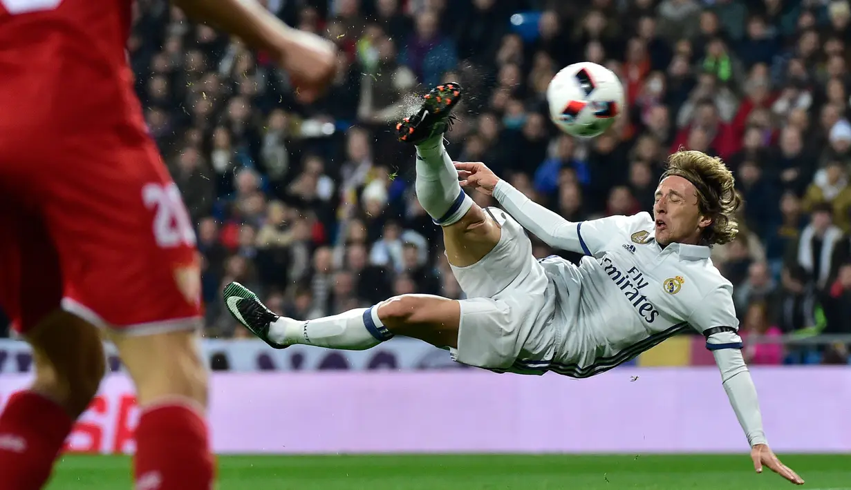 Aksi gelandang Real Madrid, Luca Modric menendang bola saat berhadapan dengan Sevilla pada pertandingan pertama babak 16 besar Copa del Rey di Santiago Bernabeu, Spanyol (5/1). Madrid menang atas Sevilla 3-0. (AFP Photo/Gerard Julien)
