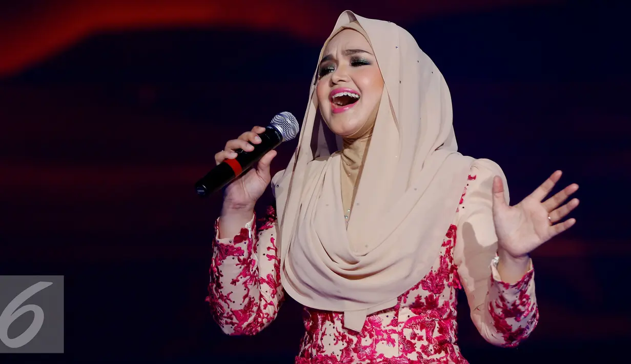 Penampilan Siti Nurhaliza saat membawakan lagu saat Konser Raya 21 Tahun Indosiar, Istora Senayan, Jakarta (11/1/2016). Tampil sederhana mengenakan busana hijba berwarna cokelat bertabur kembang berwarna merah. (Liputan6.com/Gempur M Surya)