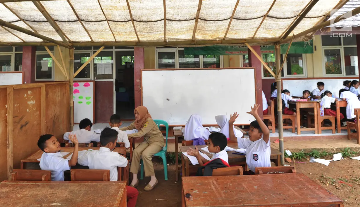 Sejumlah murid Sekolah Dasar Negeri (SDN) Mutiara mengikuti aktivitas belajar di dalam tenda darurat di Kampung Pasir Bayur, Cibeber II, Bogor, Selasa (3/4). Kurang lebih sebulan ini murid kelas 1 hingga 5 belajar di luar kelas. (Merdeka.com/Arie Basuki)