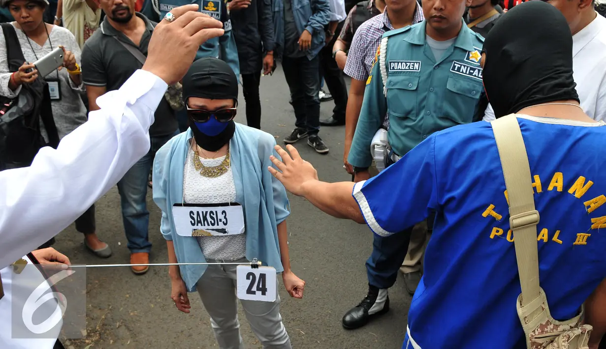 JL mendorong teman korban sebelum membunuh aktivis Jopi, saat rekonstruksi pembunuhan, Jakarta, Kamis (11/06/2015). Proses rekonstruksi tersebut terdiri dari 31 reka adegan yang diperankan oleh tersangka dan saksi-saksi. (Liputan6.com/Andrian M Tunay)