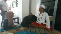 Robi Anjay dan Sayati istrinya saat meminta maaf kepada pengasuh pondok Pesantren Attaroqi Karongan KH Faurok Alawi. (liputan.com/Musthofa Aldo)