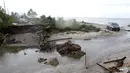 Sebuah mobil melintasi pantai karena jembatan di jalur alternatif Sumur, Banten, ambruk, Senin (24/12). Jembatan penghubung ambruk diterjang gelombang Tsunami Selat Sunda. (Liputan6.com/Angga Yuniar)