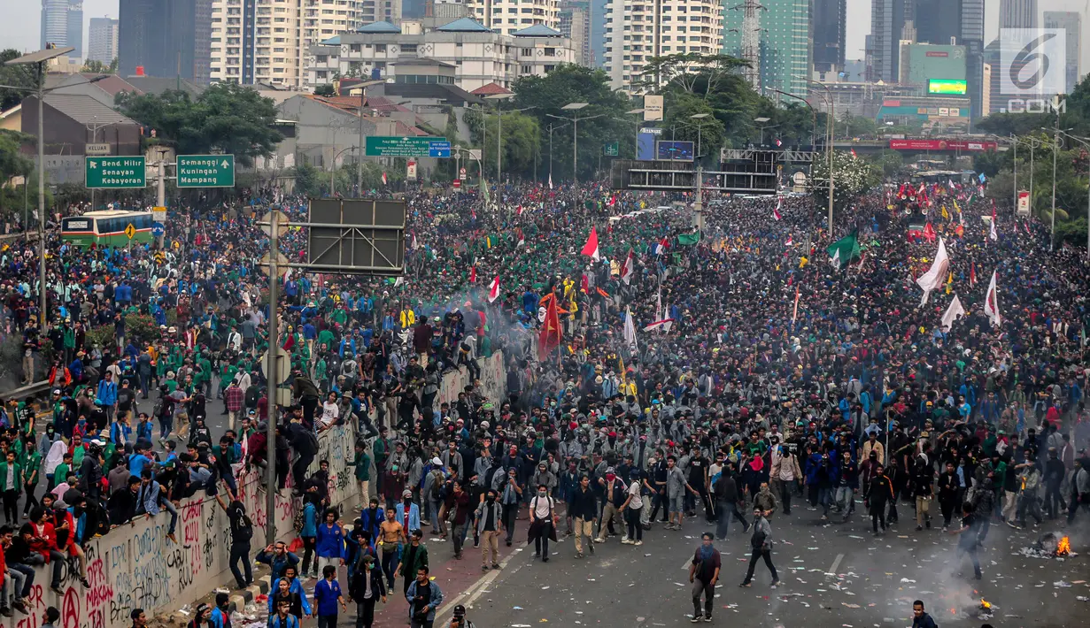 Mahasiswa berlarian saat polisi menembakkan gas air mata dalam demonstrasi menolak pengesahan RUU KUHP dan revisi UU KPK di depan Gedung DPR, Jakarta, Selasa (24/9/2019). Polisi menghalau mahasiswa yang berusaha masuk ke area Gedung DPR. (Liputan6.com/Faizal Fanani)