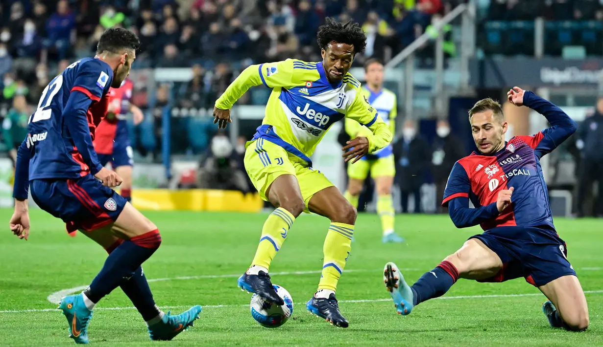 Gelandang Juventus, Juan Cuadrado (tengah) berusaha melewati dua pemain Cagliari pada pertandingan lanjutan Liga Serie A Italia di Stadion Unipol Domus, Cagliari, Italia, Minggu (10/4/2022). Juventus menang atas Cagliari 2-1. (AFP/Alberto Pizzoli)