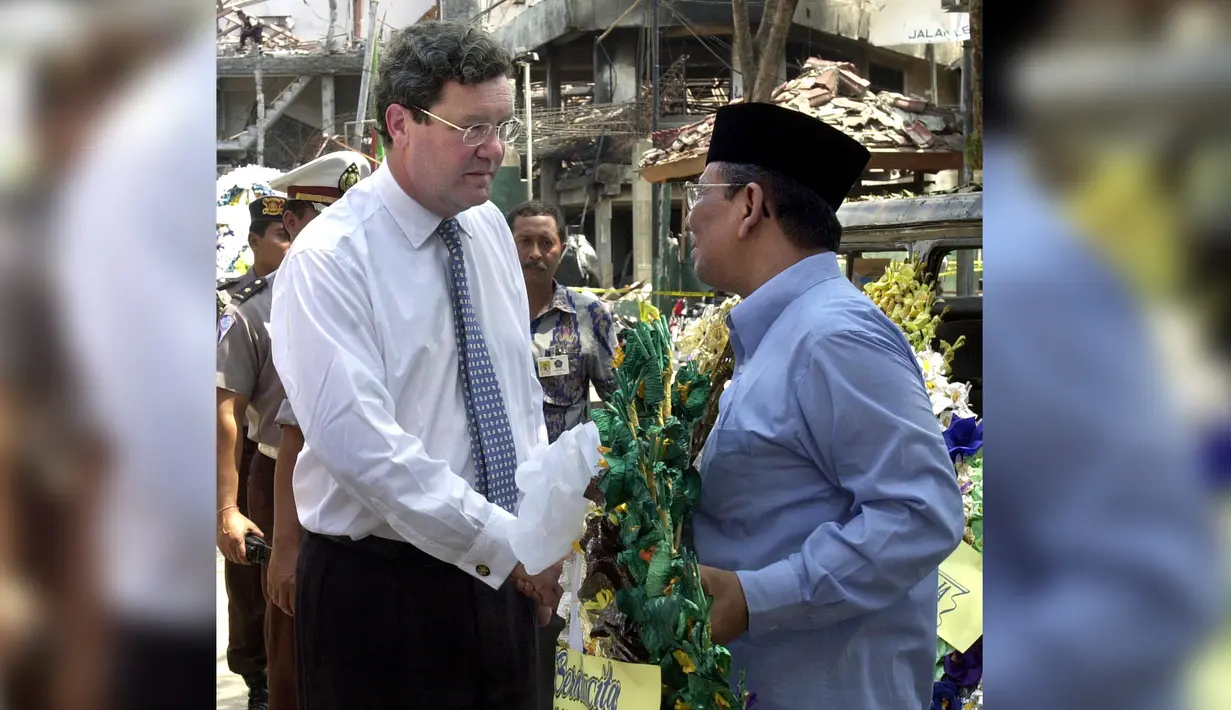 KH Hasyim Muzadi berbincang dengan Menteri Luar Negeri Australia Alexander Downer di lokasi pengeboman korban dalam ledakan 12 Oktober di kawasan wisata Kuta, Denpasar, Bali, 15 Oktober 2002. (AFP Photo/Choo Youn-Kong)