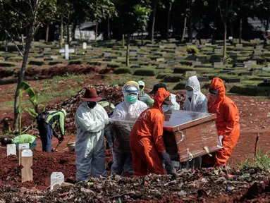 Petugas Suku Dinas Pertamanan dan Pemakaman mengenakan perlengkapan APD memakamkan jenazah pasien COVID-19 di TPU Pondok Rangon, Jakarta, Rabu (17/6/2020). (Liputan6.com/Johan Tallo)