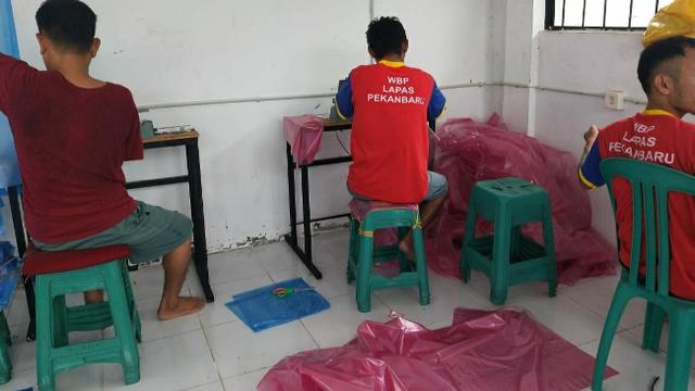 Beberapa warga binaan Lapas Pekanbaru tengah membuat jas hujan.