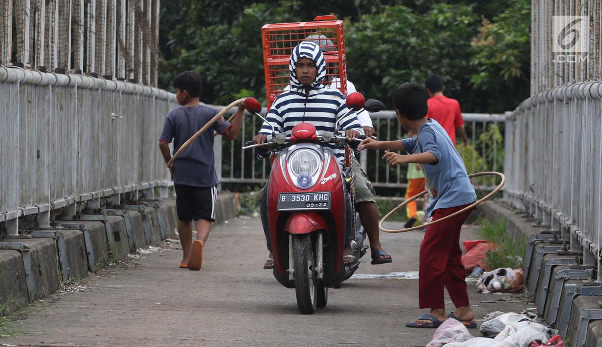 Pengendara motor melintas di samping anak-anak yang bermain di Jembatan Penyeberangan Orang kawasan Cikunir, Bekasi Barat, Senin (12/3). JPO untuk bagi pejalan kaki ini justru digunakan pemotor mencari jalan pintas. (Liputan6.com/Arya Manggala)
