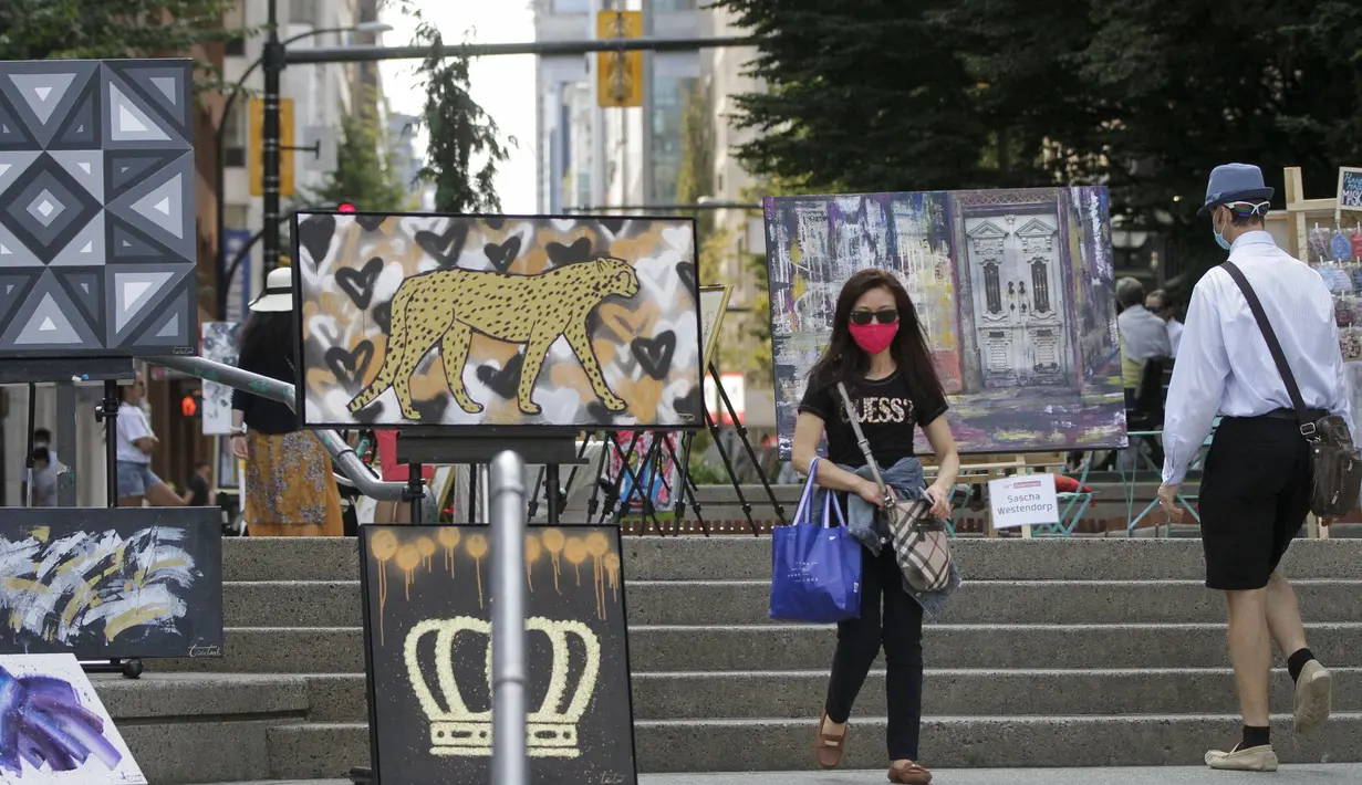 Seorang wanita mengamati karya seni yang dipajang di area terbuka dalam pameran Art Downtown, Vancouver, British Columbia, Kanada, 4 September 2020. Art Downtown merupakan proyek yang memungkinkan seniman dan publik saling terhubung dan menginspirasi serta berbagi kreativitas. (Xinhua/Liang Sen)