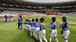 Putra putri dari anggota The Jakmania berjalan saat menjadi Player Escort Kids pada laga Piala AFC 2019 antara Persija Jakarta melawan Ceres Negros di SUGBK, Jakarta, Selasa (23/4). Kesempatan ini diberikan oleh Allianz. (Bola.com/Peksi Cahyo)