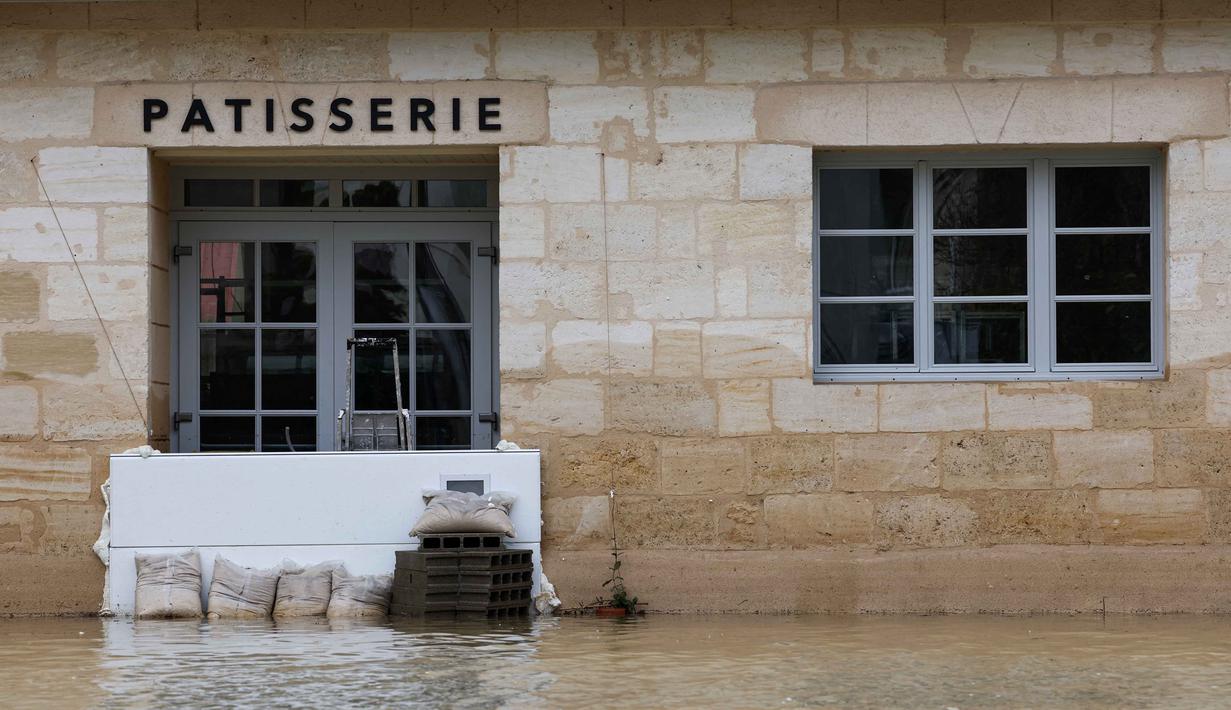 Layanan cuaca nasional Meteo-France mengatakan bahwa negara itu mengalami rangkaian musim hujan terpanjang sejak pemantauan dimulai pada tahun 1959. Tampak foto menunjukkan kondisi toko kue yang terendam banjir akibat hujan lebat yang menyebabkan luapan sungai Garonne di Sainte-Croix-du-Mont, Prancis barat pada Kamis 19 Februari 2026. (ROMAIN PERROCHEAU/AFP)