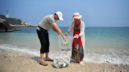 Turis mengumpulkan sampah di sepanjang Teluk Mulan, Kota Wenchang, Provinsi Hainan, China pada 28 April 2020. Fasilitas bank sampah dibuat dengan wisatawan dapat menukarkan sampah yang mereka kumpulkan di pantai dengan hadiah, seperti air kemasan, kelapa serta makanan ringan. (Xinhua/Guo Cheng)