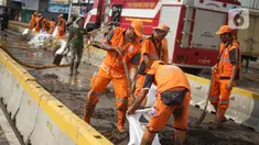 Petugas Penanganan Prasaran dan Sarana Umum (PPSU) membersihkan lumpur yang mengendap di sepanjang Jalan Jatinegara Barat, Kampung Melayu, Jakarta Timur, Kamis (2/1/2020). Petugas melakukan bersih-bersih menyusul mulai surutnya banjir di kawasan tersebut. (Liputan6.com/Immanuel Antonius)