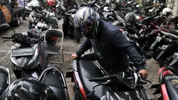 Pegawai kantor Balai Kota DKI Jakarta mengambil motor yang diparkir di halaman Kelurahan Kebon Sirih, Jakarta, Rabu (16/1). Naiknya tarif parkir di IRTI Monas juga menyebabkan halaman Kelurahan tersebut dipenuhi sepeda motor. (Merdeka.com/Iqbal S Nugroho)