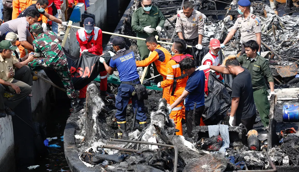 Tim SAR gabungan mengevakuasi jenazah dari atas kapal Zahro Express yang terbakar, di Pelabuhan Muara Angke, Jakarta, Minggu (1/1). Kebakaran kapal penumpang di perairan Pulau Untung Jawa itu diduga berawal dari mesin kapal. (REUTERS/Darren Whiteside)
