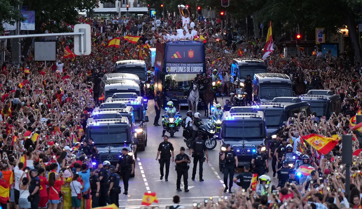 <p>Timnas Spanyol diarak menggunakan bus terbuka menuju Cibeles Square saat perayaang kemenangan Euro 2024 di Madrid, Spanyol, Senin (15/07/2024) waktu setempat. (AFP/Cesar Manso)</p>