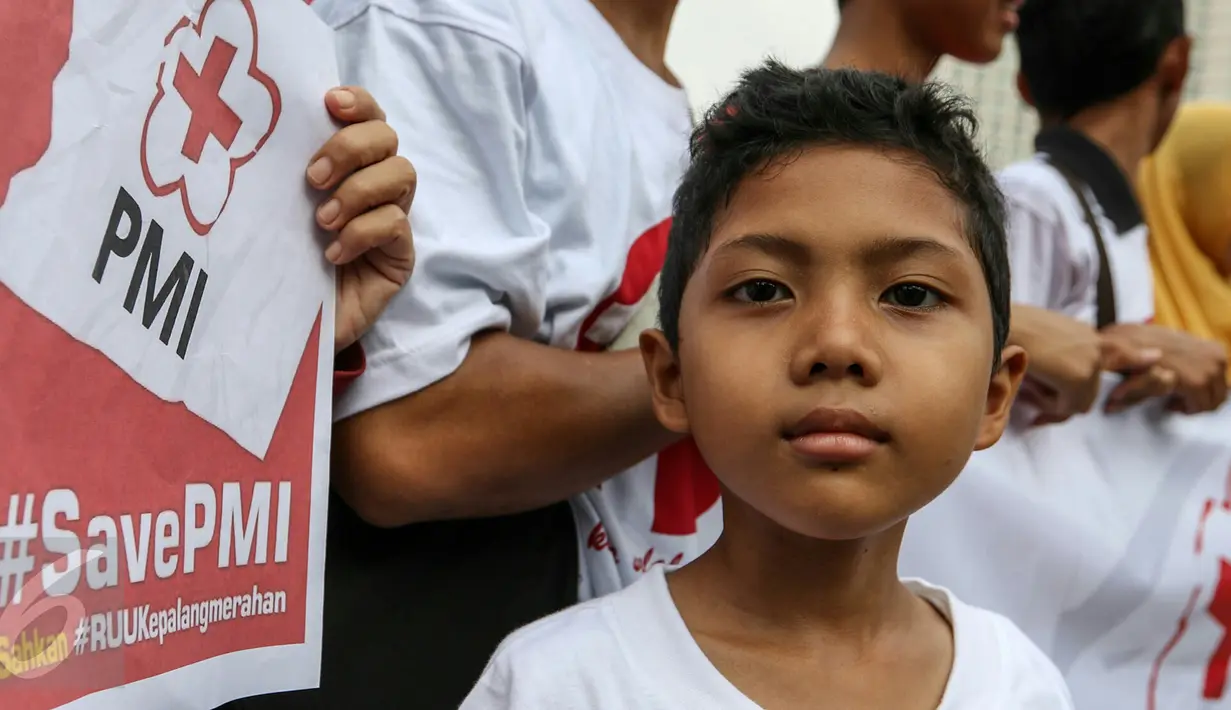 Seorang anak ikut dalam aksi sukarelawan PMI di acara car free day, Bunderan HI, Jakarta, Minggu (6/3). Ratusan sukarelawan PMI meminta DPR untuk segera mengesahkan RUU Kepalangmerahan menjadi UU Kepalangmerahan pada tahun ini.(Liputan6.com/Yoppy Renato)