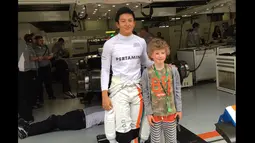Pebalap Manor Racing asal Indonesia, Rio Haryanto, bersama penggemar ciliknya, Milo, jelang kualifikasi F1 GP China di Sirkuit Internasional Shanghai, China, Sabtu (16/4/2016). (Bola.com/Twitter/Manorracing)
