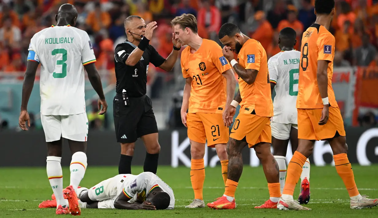 Gelandang Senegal #08 Cheikhou Kouyate terbaring di lapangan setelah mengalami cedera pada pertandingan kedua Grup A Piala Dunia 2022 di Stadion Al-Thumama di Doha, Senin (21/11/2022). Gelandang Timnas Belanda, Frenkie de Jong, secara tidak sengaja menyentuh bagan vital Cheikhou Kouyate saat berebut bola di udara. (OZAN KOSE / AFP)