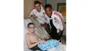 Seorang anak yang sedang sakit tampak senang menerima kado natal dari pemain Manchester United, Anthony Martial dan Morgan Schneiderlin. (www.manutd.com)