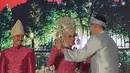 Beskap Verrell dipadukan dengan bawahan kain songket motif silver di atas celana panjang warna baby bluenya. Tampak ia pun naik ke atas pelaminan untuk memberi selamat kepada kedua mempelai.  [@bramastavrl]