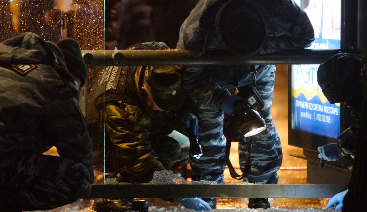 Polisi memeriksa sebuah halte bus yang rusak akibat terkena ledakan di Moskow, Rusia, Senin (7/12). Tiga orang luka terkena pecahan kaca. Bahan peledak diperkirakan dilemparkan dari mobil atau bangunan perumahan di dekatnya. (AFP/NATALIA Kolesnikova)