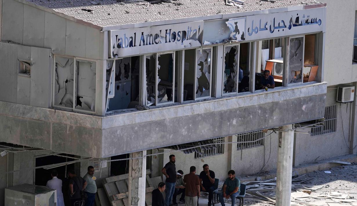 Orang-orang berkumpul di pintu masuk Rumah Sakit Jabal Amel yang rusak, setelah serangan udara Israel pada Senin (1/6) yang menghantam gedung di dekatnya, di kota pelabuhan selatan Tyre, Lebanon, Selasa 2 Juni 2026. (AP Photo/Mohammed Zaatari)