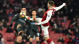 Gelandang Arsenal, Aaron Ramsey, berebut bola dengan gelandang Manchester City, Ilkay Gundogan, pada laga Premier League di Stadion Emirates, London, Kamis (1/3/2018). Arsenal kalah 0-3 dari City. (AFP/Glyn Kirk)