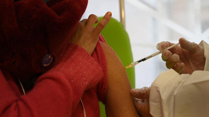 Seorang wanita menerima suntikan vaksin virus corona COVID-19 di Rumah Sakit San Filippo Neri, Roma, Italia, 28 Desember 2020. Dalam pelaksanaannya, Italia menggunakan vaksin COVID-19 buatan Pfizer-BioNTech. (Xinhua/Alberto Lingria)