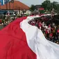 Warga Kota Bogor mengarak bendera merah putih raksasa. Kegiatan kirab ini digelar dalam rangkaian Festival Merah Putih (FMP) yang diselenggarakan selama satu bulan untuk menyemarakkan HUT ke-78 Kemerdekaan RI. (Liputan6.com/Achmad Sudarno)