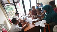 Petugas memberikan informasi kepada warga terkait pembuatan akte kelahiran dan e-KTP di Jakarta Timur, Senin (28/12). Proses pengurusan yang lebih mudah membuat warga membuat akte dan e-KTP jelang pergantian tahun. (Liputan6.com/Immnuel Antonius)