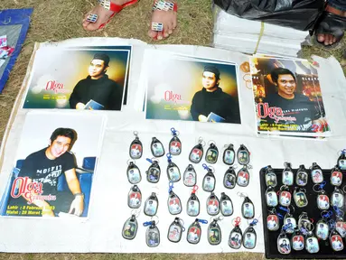 Salah satu pedagang yang menjual gantungan kunci dan poster bergambar Olga Syahputra di TPU Malaka, Jakarta, Selasa (31/3/2015). Empat hari pascakepergian komedian Olga, antusiasme masyarakat berkunjung ke makam masih tinggi. (Liputan6.com/Panji Diksana)