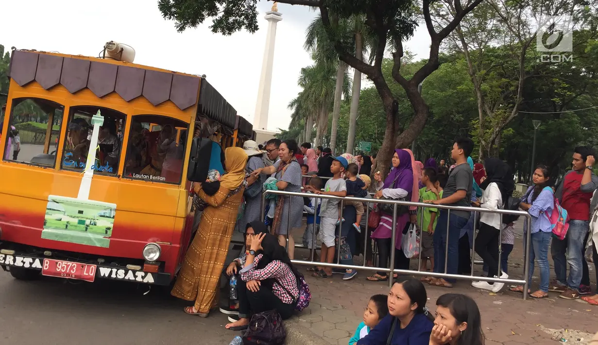 Warga mengantre untuk menaiki mobil keliling di Silang Monas, Jakarta, Sabtu (30/12). Kawasan Monas ramai pengunjung dan menjadi pilihan warga untuk menikmati libur akhir tahun yang bersamaan dengan masa libur sekolah. (Liputan6.com/Immanuel Antonius)