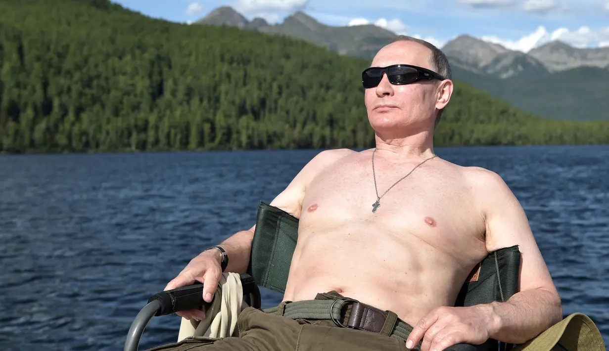 Foto yang dirilis oleh layanan pers Kremlin pada hari Sabtu, 5 Agustus 2017, Presiden Rusia Vladimir Putin beristirahat setelah memancing selama liburan mini di kawasan Siberia Tyva. (Alexei Nikolsky / Sputnik, Foto Kolam Kremlin via AP)