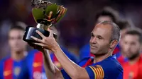 Kapten Barcelona, Andres Iniesta, mengangkat trofi juara Trofeo Joan Gamper 2016 di Camp Nou, Kamis (11/8/2016) dini hari WIB. (AFP/Josep Lago)