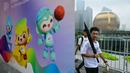 Sejumlah pejalan kaki melewati poster Asian Games 2022 yang terletak di sepanjang Sungai Qiantang di Hangzhou, Zhejiang, China pada 22 September 2023 waktu setempat. (AFP/Manan Vatsyayana)