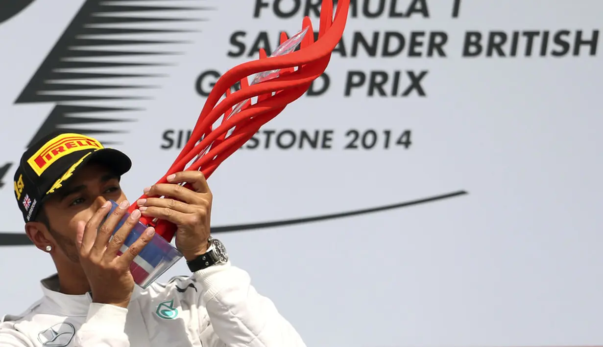 Selebrasi pembalap Formula Satu dari tim Mercedes, Lewis Hamilton, usai memenangi GP Inggris yang dihelat di Sirkuit Silverstone, (6/7/2014). (REUTERS/Francois Lenoir)