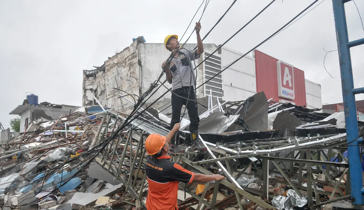 Petugas membenahi kabel listrik menyusul insiden ledakan yang terjadi di outlet Pizza Hut Delivery (PHD) Jatimelati, Bekasi, Minggu (23/10).  Akibat ledakan itu, listrik padam hingga radius 300-500 meter dari lokasi kejadian. (Liputan6.com/Yoppy Renato)